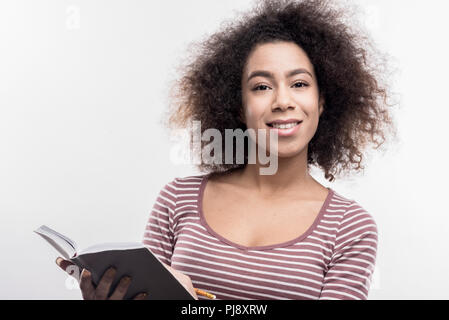 Dark-eyed curly manager curiosa sensazione durante il lavoro sul suo nuovo progetto Foto Stock