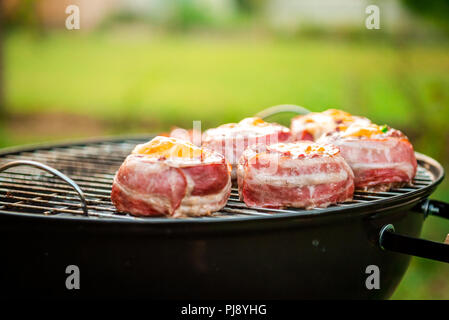 Rendendo fatta in casa birra può Bacon gli hamburger sul grill barbecue. La preparazione di polpette ripiene, avvolto in pancetta e grigliare sul calore indiretta nella natura a bac Foto Stock