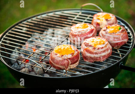 Rendendo fatta in casa birra può Bacon gli hamburger sul grill barbecue. La preparazione di polpette ripiene, avvolto in pancetta e grigliare sul calore indiretta nella natura a bac Foto Stock