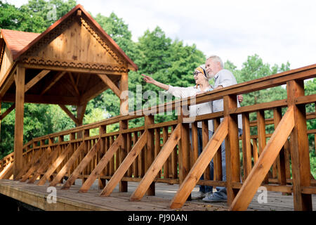 Paio di alti personaggi in piedi sul grande ponte di legno Foto Stock