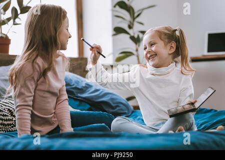 Bella ragazza felice azienda trucco pennello Foto Stock