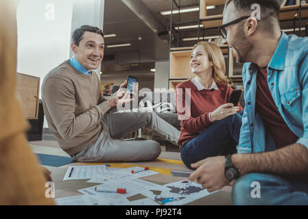 Positivo a tre colleghi spettegolare Foto Stock