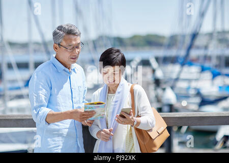 Giapponese coppia senior divertirsi in riva al mare Foto Stock