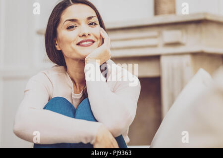 Felice bella donna che mantiene il suo mento Foto Stock