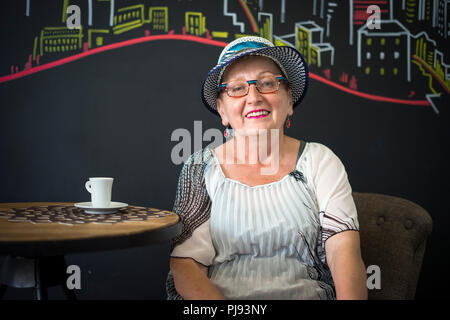 Eleganti Donna anziana di bere il caffè nel bar posto Foto Stock