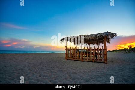Fantastica spiaggia di Varadero al tramonto,a metà un di legno e paglia tenda per massaggi sulla spiaggia, Varadero Cuba. Foto Stock