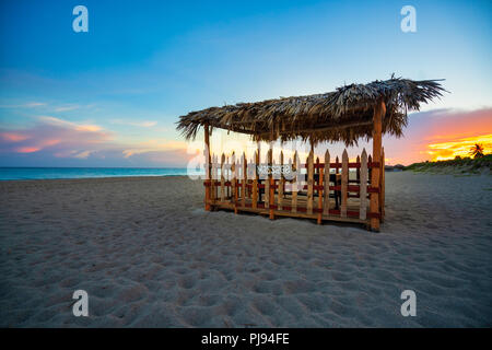 Bellissima spiaggia di Varadero al tramonto,a metà un di legno e paglia tenda per massaggi sulla spiaggia, Varadero Cuba. Foto Stock