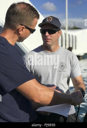 Sito ufficiale della Royal Navy Officer in miniera di carica l'eliminazione degli ordigni esplosivi, Chief Petty Officer Ciad Buhlmann (destra), discute l'immersione sulla USS Arizona con Chief Diver David Partin dalla United States Coast Guard durante RIMPAC 2018. Venticinque nazioni, 46 navi, cinque sommergibili, circa 200 aerei, e 25.000 personale partecipano RIMPAC dal 27 giugno al 2 agosto in e intorno alle Isole Hawaii e la California del Sud. Il più grande del mondo marittimo internazionale esercitazione RIMPAC offre una singolare opportunità di formazione promuovendo e sostenendo le relazioni cooperative tra le pa Foto Stock