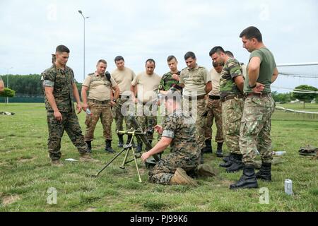 Stati Uniti Marines con il Mar Nero forza rotazionale (BSRF) 18.1 dimostrare le armi fondamentali di un M224 60mm leggero sistema mortaio di soldati rumeni a bordo di Mihail Kogalniceanu Air Base, Romania, Luglio 3, 2018. Lo scopo di BSRF è quello di mantenere le relazioni con i nostri alleati e partner le nazioni attraverso vari eventi di formazione in tutta la distribuzione. Foto Stock