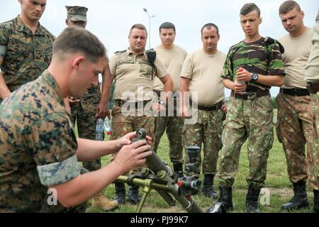 Stati Uniti Marines con il Mar Nero forza rotazionale (BSRF) 18.1 dimostrare le armi fondamentali di un M224 60mm leggero sistema mortaio di soldati rumeni a Mihail Kogalniceanu Air Base, Romania, Luglio 3, 2018. Lo scopo di BSRF è quello di mantenere le relazioni con i nostri alleati e partner le nazioni attraverso vari eventi di formazione in tutta la distribuzione. Foto Stock