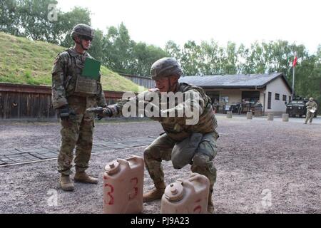 Sgt. Andrew Pitts, 30 vigili del medico, conduce squat mentre sulla gamma per il XXI Theatre supporto del comando guerriero migliore concorrenza stress sparare in Baumholder, Germania il 10 luglio. Pitts ha condotto un certo numero di faticosi allenamenti fisici in piena marcia prima di sparare la sua M9 9mm pistola alla gamma. Foto Stock