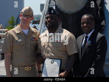 Lt(JG) Christopher Eastman (sinistra) sorge accanto a AO2(AW) Brandon Howard e suo zio, pensionato U.S grande esercito Frederick Perkins. AO2(SW) Howard è assegnato al mare in elicottero contro lo squadrone di nove, e appena ri-arruolato. Il re-arruolamento ha preso posto a bordo del U.S.S Wisconsin (BB-64), una nave museo ormeggiata permanentemente accanto all'Hampton Roads Museo Navale in Downtown Norfolk, Virginia. Foto Stock