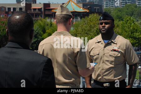 AO2(AW) Brandon Howard sorge presso l'attenzione come egli è onorevolmente scaricato dall'U.S Navy da lt(JG) Christopher Eastman. AO2(AW) Howard è assegnato al mare in elicottero contro lo squadrone di nove, e poco dopo essere stato scaricato, orgogliosamente ri-arruolato. Il re-arruolamento ha preso posto a bordo del U.S.S Wisconsin (BB-64), una nave museo ormeggiata permanentemente accanto all'Hampton Roads Museo Navale in Downtown Norfolk, Virginia. Foto Stock