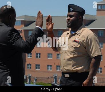 Ritirato grande esercito Frederick Perkins amministra il giuramento di re-arruolamento a suo nipote, AO2(AW) Brandon Howard, chi è assegnato al mare in elicottero squadrone di combattimento nove. Il re-arruolamento ha preso posto a bordo del U.S.S Wisconsin (BB-64), una nave museo ormeggiata permanentemente accanto all'Hampton Roads Museo Navale in Downtown Norfolk, Virginia. Foto Stock