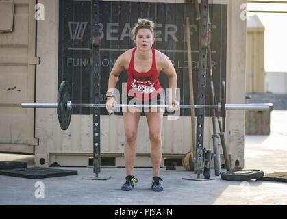 Master Sgt. Kimberly Kaminski, 380 Expeditionary forze di sicurezza Squadron, completa un barbell bancata posteriore durante il suo allenamento Al Dhafra Air Base, negli Emirati Arabi Uniti il 12 luglio 2018. Kaminski compie un esercizio di routine 6 su 7 giorni a settimana. Foto Stock