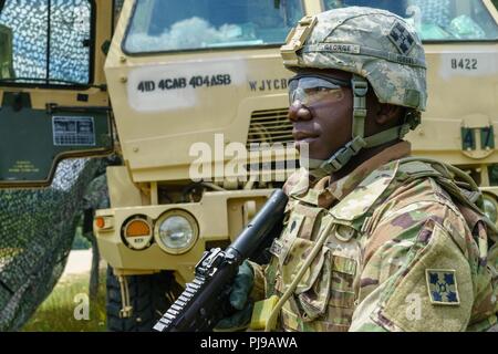 Spc. Ishnel George, un specialista di comunicazione con la società B, 404 Aviazione Battaglione di supporto, 4a combattere la Brigata Aerea, 4a divisione di fanteria, scandisce il suo settore a una voce del punto di controllo che fissa il battaglione mobile dell area in avanti punto di rifornimento (FARP) durante una prontezza esercitazione a Hohenfels Area Formazione, Germania, 12 luglio, 2018. I soldati del battaglione stanno svolgendo il loro primo esercizio di preparazione dal momento che giungono in Europa per risolvere atlantico, gli Stati Uniti si sforzano di adempiere gli impegni della NATO ruotando U.S. unità basate su tutto il teatro europeo a dissuadere aggressione ag Foto Stock