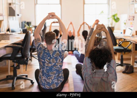 Attività creativa di persone a praticare yoga in ufficio Foto Stock