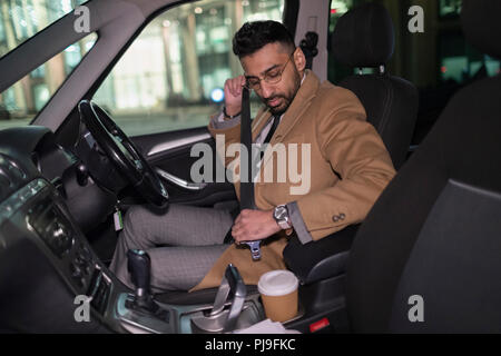 Imprenditore imbozzamento cintura di sicurezza in auto Foto Stock