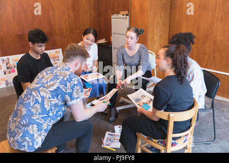 Progettisti creativi rivedendo le prove in office meeting Foto Stock