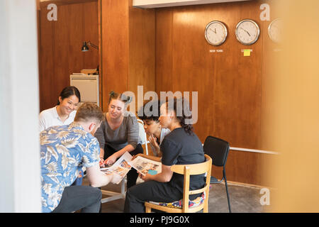 Progettisti creativi rivedendo le prove in office meeting Foto Stock