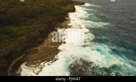 Costa rocciosa linea nel tempo le tempeste sull isola Siargao. Vista aerea del mare costa rocciosa, di onde che si infrangono al litorale roccioso. Costa rocciosa. Grandi onde schiacciamento sulla riva. Filippine. Concetto di viaggio. Foto Stock