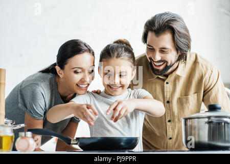 La famiglia felice con la mia bambina frittata di cottura in cucina Foto Stock