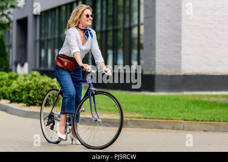 Bella donna attraente seduti sulla bici su strada Foto Stock