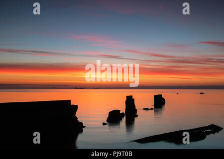 Sunrise colorati del seawall rotto in corrispondenza di Seafield, Kirkcaldy Fife Scozia Scotland Foto Stock