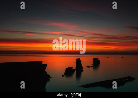 Sunrise colorati del seawall rotto in corrispondenza di Seafield, Kirkcaldy Fife Scozia Scotland Foto Stock