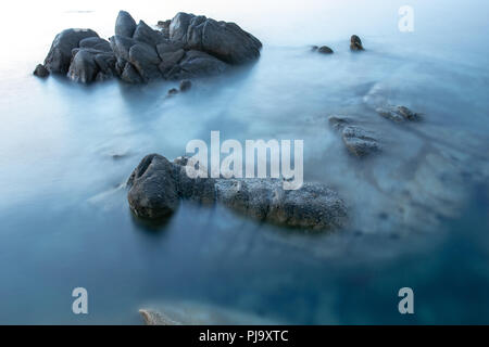 Spiaggia rocciosa lunga esposizione dopo il tramonto, di Vourvourou, Sithonia, Calcidica, Grecia Foto Stock