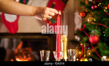 Primo piano immagine della mano candela di illuminazione sulla cena di Natale tabella Foto Stock