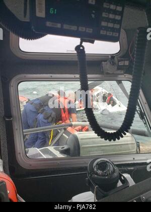 Una stazione della Guardia Costiera Islamorada 33-piede Special Purpose Craft-Law esecuzione boatcrew rescue nove persone dall'acqua dopo il loro 19-piede barca capovolta in galline e polli Reef, Florida, Luglio 5, 2018. Tutte e nove le persone a bordo di imbarcazioni da diporto sono stati soccorsi e trasportati in un locale di marina dalla Coast Guard boatcrew con assenza di lesioni riportate. Coast Guard Foto Stock