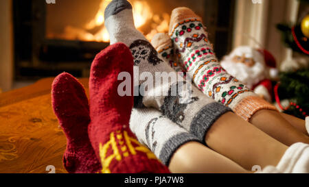 Famiglia nel caldo calze di lana riscaldamento del caminetto a casa Foto Stock