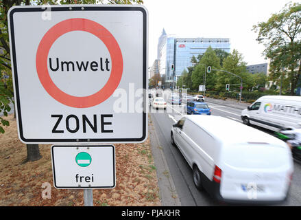 06.09.2018, Hesse, Frankfurt am Main: macchine passano un segno di traffico su Theodor-Heuss-Allee vicino alla fiera di Francoforte con la scritta "Umwelt zona'(zona ambientale). Secondo la decisione del Tribunale amministrativo di Wiesbaden, Francoforte sarà un altra metropoli tedesca ad essere vietata dalla guida i veicoli diesel nel 2019. Foto: Arne Dedert/dpa Foto Stock