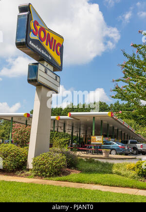 NEWTON, NC, Stati Uniti d'America-9/2/18: una Sonic drive-in un ristorante fast food, mostrando un cartello stradale e guidare il servizio. 4 persone visibili nella tabella sotto la tenda. Foto Stock