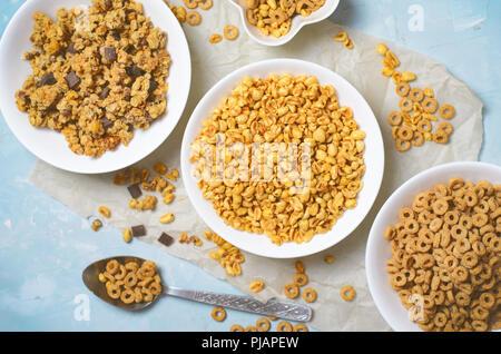Diversi tipi di cereali, veloce colazione, snack sani, riso soffiato, loop di cereali e muesli al cioccolato Foto Stock