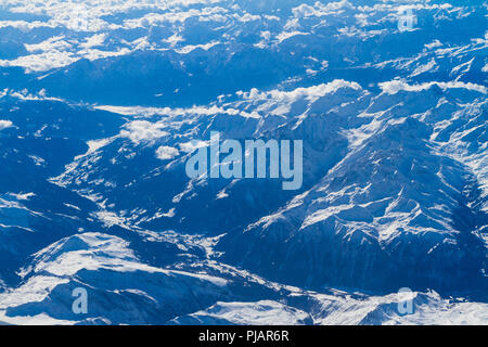 Antenna unica vista impressionante cumulus temporale corpi nuvole su strade coperte di neve a sud Europa centrale regione montana visto attraverso un aereo wi Foto Stock