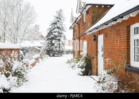 English country home in inverno con una strada coperta di neve Foto Stock