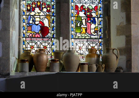 Corfe, Dorset, Regno Unito - 03 GIU 2018: Raccolta di argilla tradizionali post e vasi, visualizzata su un davanzale di pietra di fronte un ornato colorato colorato Foto Stock