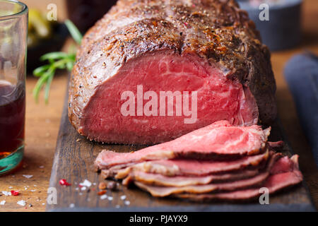 Arrosto di manzo sul tagliere. Sfondo di legno. Close up. Foto Stock