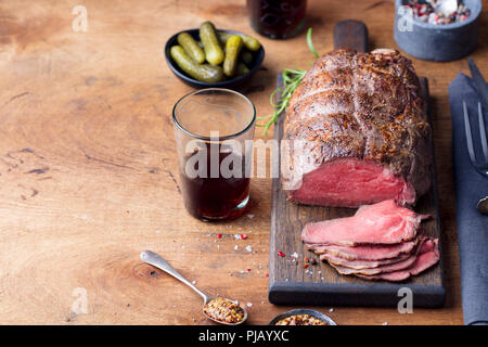 Arrosto di manzo sul tagliere. Sfondo di legno. Copia dello spazio. Foto Stock