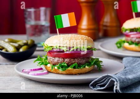 Burger con bandiera irlandese sulla parte superiore. Sfondo di legno. Close up. Foto Stock