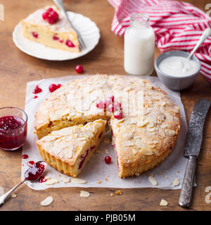 La mandorla e lampone torta, Bakewell tart. Tradizionale pasticceria britannico. Sfondo di legno. Foto Stock