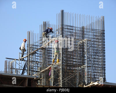 Lavoratori edili installazione barra di rinforzo sul sito di costruzione. La barra di rinforzo è il componente principale per il rinforzo di calcestruzzo. Foto Stock