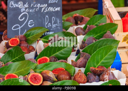 Mature Mediterranean Purple figure in vendita con una lavagna segno 'Casella di figure dalla Spagna 2 Euro" presso il locale all'aperto il mercato degli agricoltori a Nizza, Foto Stock