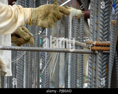 Lavoratori edili installazione barra di rinforzo sul sito di costruzione. La barra di rinforzo è il componente principale per il rinforzo di calcestruzzo. Foto Stock