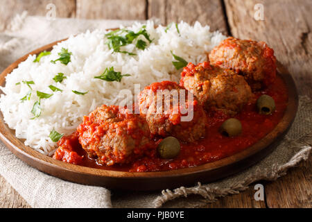 Tradizionale greco per le polpette di carne in salsa di pomodoro con riso close-up su una piastra su un piano orizzontale. Foto Stock