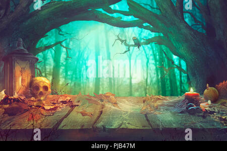 Tema Halloween con zucche, il cranio e la foresta scura. Scary Halloween design sul tavolo Foto Stock