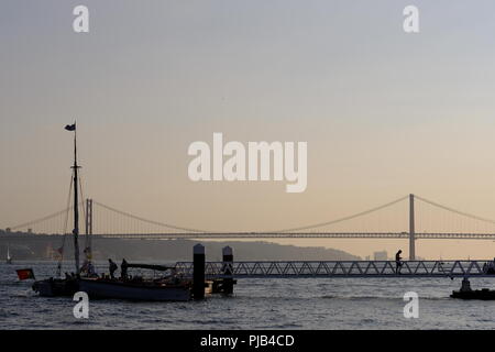 Vista sul Fiume Tolgus barche di Lisbona e pointe Ponte 25 Abril Foto Stock