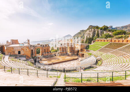 Le rovine del Teatro Greco di Taormina e la pittoresca catena montuosa dal vulcano Etna a Castelmola in background. Taormina, Sicilia, Ita Foto Stock